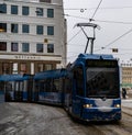 Blue tram rides around town, transport