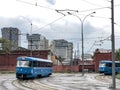 Blue trams on the background of an old red tram depot.