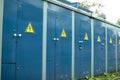 Blue transformer box.Locked electric metal door with a sign of attention on the blue wall of the transformer substation