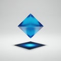 A blue, translucent octahedron hovers above a gray surface. The geometric shape Royalty Free Stock Photo