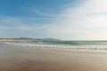 Blue transparent sky with lacy white clouds over the ocean. Mountains can be seen in the distance. Pastel shades. Beautiful nature Royalty Free Stock Photo