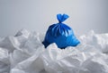 Blue trash bag on a white surface, AI-generated. Royalty Free Stock Photo