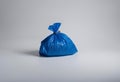 Blue trash bag on a white surface, AI-generated. Royalty Free Stock Photo