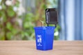 Blue trash can model containing recyclable garbage opens the lid to grow buds. The Chinese characters on the trash can mean`Recycl