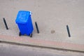 Blue trash can on street pavement Royalty Free Stock Photo