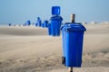 Blue trash cans dustbin on an empty beach Royalty Free Stock Photo