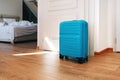 Blue travel suitcase in hotel apartment