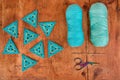 Blue triangle crochet patterns, two skeins of yarn, a hook and scissors on brown wood background. Royalty Free Stock Photo