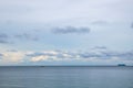 Blue tropical seascape with lone long tail boat and a distant island Royalty Free Stock Photo