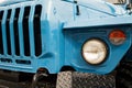 Blue truck front close-up with radiator grille and headlights