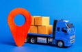 A blue truck loaded with boxes and a red pointer location. Services transportation of goods, products, logistics Royalty Free Stock Photo