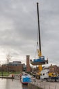 blue tug boat dropped into water by crane