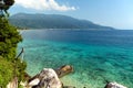 Blue turquoise transparent clear sea water, large stones along the coast, blue sky with white clouds Royalty Free Stock Photo