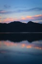 Blue twilight sky and dark mountains reflected on the calm waters of a lake. Calm, peaceful scene. Royalty Free Stock Photo