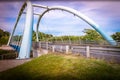 Blue Twin Arch Suspension Bridge with grass embankment Royalty Free Stock Photo