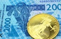 A blue two thousand West African franc note with a gold coin in macro Royalty Free Stock Photo