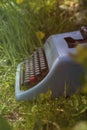 Blue typewriter on the grass