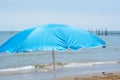 A blue umbrella on the beach in front of the sea Royalty Free Stock Photo