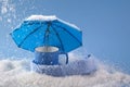 Blue umbrella and cup of coffee on blue background with snow. Blue monday concept. Royalty Free Stock Photo