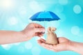 Blue Umbrella protection sack bag with money in hand man savings a business. Protection money concept Royalty Free Stock Photo