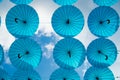 Blue umbrellas float in sky on sunny day. Umbrella sky project installation. Holiday and festival celebration. Shade and