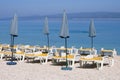 Blue umbrellas and loungers for relax and comfort on sea beach. Happy summer vacations and tourism concept. Paid service on