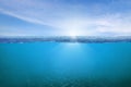 BLUE UNDER WATER waves and bubbles. Beautiful white clouds on blue sky over calm sea with sunlight reflection Royalty Free Stock Photo