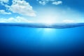 BLUE UNDER WATER waves and bubbles. Beautiful white clouds on blue sky over calm sea with sunlight reflection, Tranquil sea Royalty Free Stock Photo