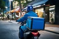 Blue uniformed rider delivers food or parcels efficiently on a motorcycle