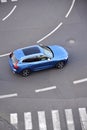 Blue unrecognizable car moving on road with broken line near pedestrian crossing, driverless autonomous technology concept