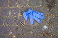 blue used latex glove abandoned in the street during the covid-19 pandemic