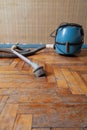 Blue vacuum cleaner stands on shabby parquet floor