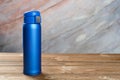 Blue vacuum tumbler with safety lock on wood table with copy space