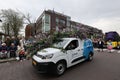 Blue van adorned with colorful flower decorations at the Flower Parade Bollenstreek