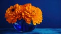 a blue vase filled with orange flowers on a table top Royalty Free Stock Photo