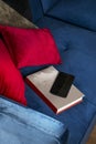 A blue velvet sofa with a book and a mobile phone on the seat Royalty Free Stock Photo