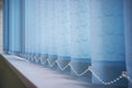 Blue vertical blinds on the long window on balcony. Modern interior design. Closed window from sunlight Royalty Free Stock Photo