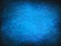 Blue Vintage abstract grunge background with bright center spotlight. Modern texture with dark corners Royalty Free Stock Photo
