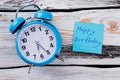 Blue vintage alarm clock and paper with happy birthday tagline.