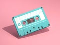 Blue vintage audio cassette on pink background