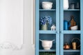 Blue vintage cupboard with kitchenware against white copy space wall