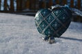 Blue vintage heart closeup in the snow in the foreground