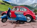 Blue vintage scooter and red vintage car parked in Austrian Alps. Fontanella, Austria.