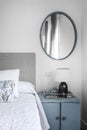 Blue vintage side table and gray fabric upholstered bedroom headboard