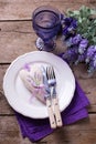 Blue and violet flowers, heart, knife and fork on white plate