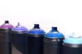 Blue and violet spray cans on graffiti on an isolated white background close-up. Royalty Free Stock Photo