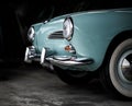 A vintage blue Volkswagen Karmann Ghia in the garage