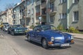 Blue VW Karmann Ghia driving with old cars