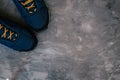 Blue warm winter or autumn sneakers with orange shoe laces on dark gray concrete surface, top view. Copy space. Flat lay Royalty Free Stock Photo