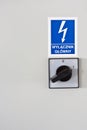 Blue warning sign with lightning and inscription plate `main switch` on the electrical cabinet in Polish language.